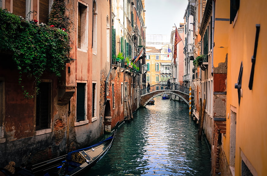 Narrow Venice Canal with Gondola and Arched Bridge