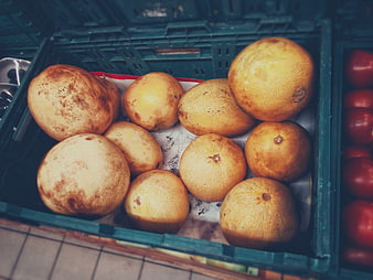 Yellow melons in a green crate at a market