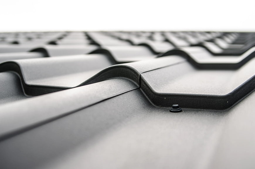Close-up of gray metal roofing sheets with industrial texture