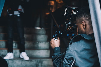Cameraman filming video on stairs with professional camera