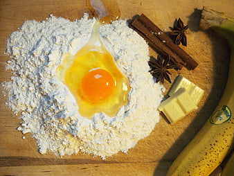 Baking ingredients with flour, egg, banana, and spices on wood