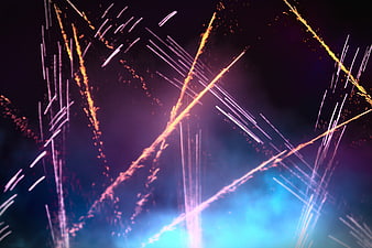 Abstract colorful fireworks trails against dark night sky