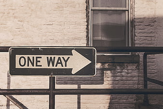 Vintage One Way Street Sign on White Brick Wall