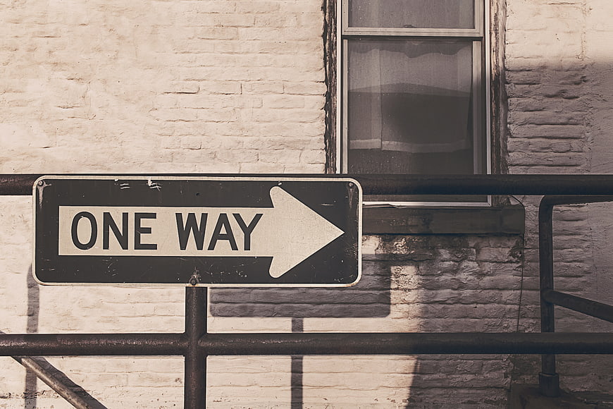 Vintage One Way Street Sign on White Brick Wall