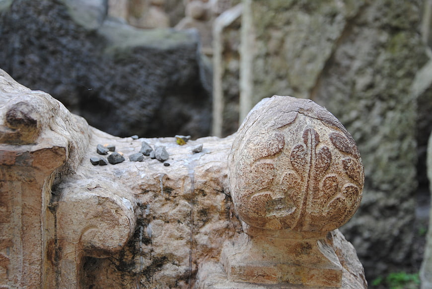 Close-up of weathered stone carving with floral relief pattern
