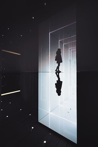 Silhouette of woman walking in futuristic neon light corridor