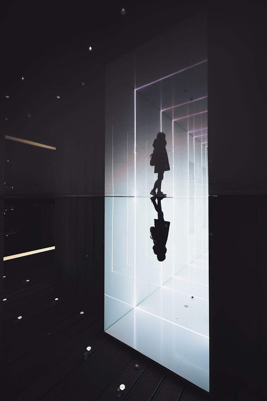 Silhouette of woman walking in futuristic neon light corridor