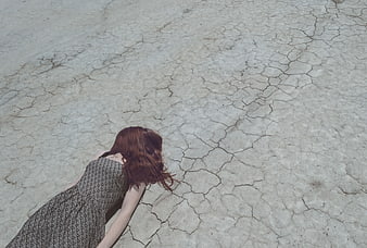 Woman in Dress Lying on Cracked Dry Earth
