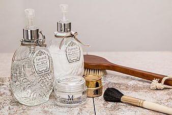 Luxury Skincare Products and Brushes on Textured Surface