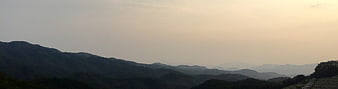 Panoramic View of Hazy Mountain Ranges at Sunset