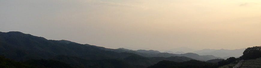 Panoramic View of Hazy Mountain Ranges at Sunset