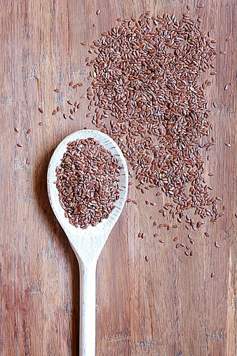 Brown Flax Seeds on Wooden Spoon and Table