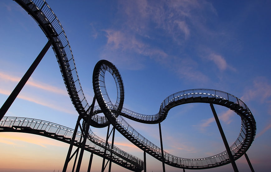 Roller Coaster Track Silhouette Against Blue Sky