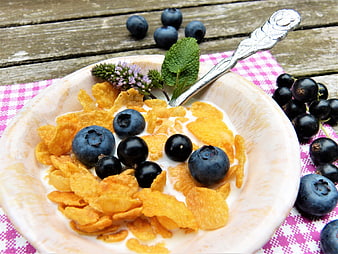 Healthy Breakfast Bowl With Corn Flakes, Milk, Blueberries, and Black Currants