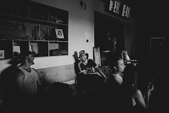 Black and white photo of men laughing in a dimly lit room