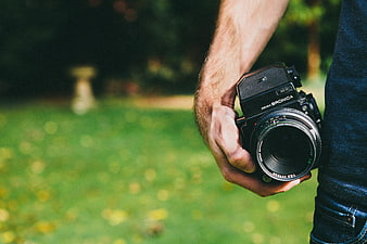 Hand holding vintage Bronica SLR camera in park