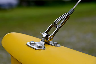 Close-up of metal cable clamp on yellow industrial equipment
