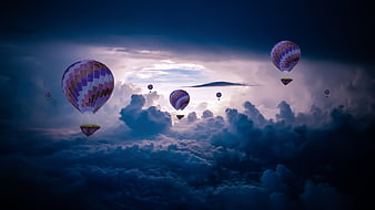 Hot Air Balloons Flying Above Clouds at Dusk