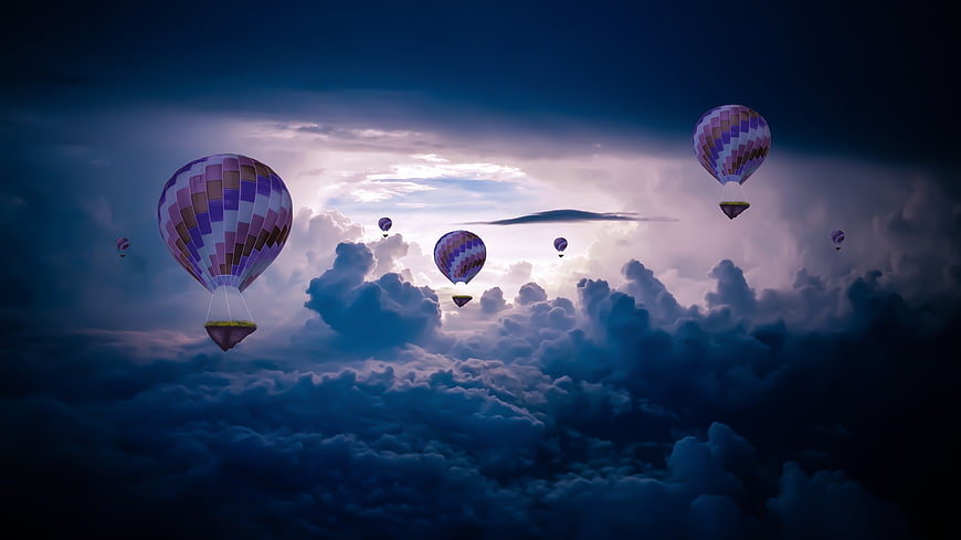 Hot Air Balloons Flying Above Clouds at Dusk