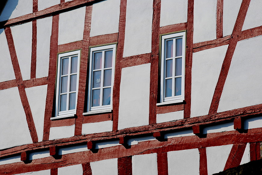 Red and white half-timbered house facade with windows
