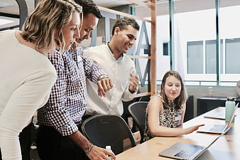 Diverse business team collaborating around laptops in modern office