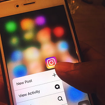 Close-up of finger tapping Instagram app on smartphone screen