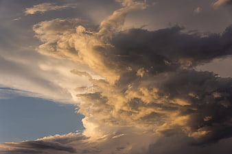 Dramatic golden sunset clouds against blue sky