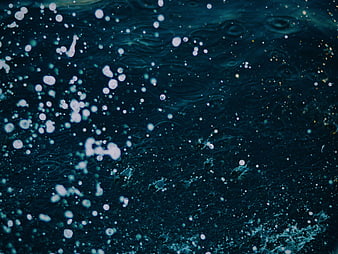 Dark blue water surface with bubbles and ripples