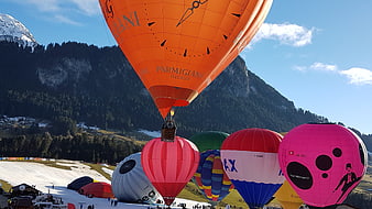 Colorful Hot Air Balloons Inflating in Alpine Valley