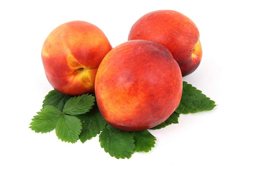 Fresh Ripe Nectarines on Green Leaves Isolated on White