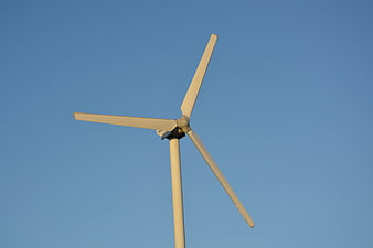 White Wind Turbine Against Clear Blue Sky