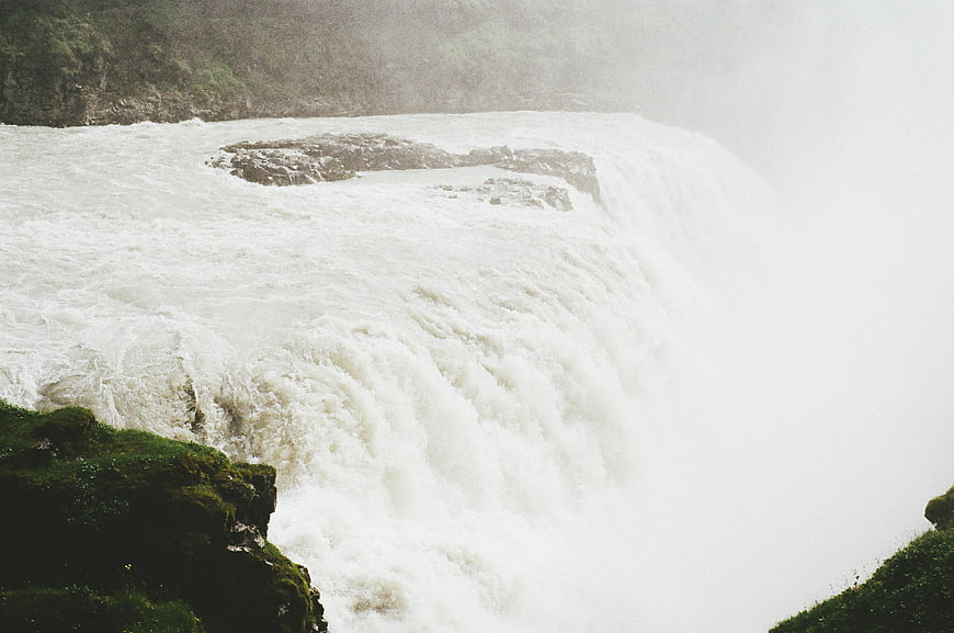 Powerful waterfall cascading over mossy rocks into mist
