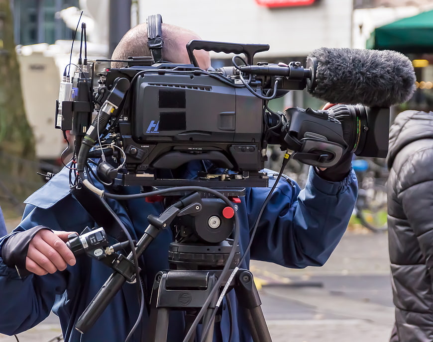 Professional Camera Operator Filming with Broadcast Equipment