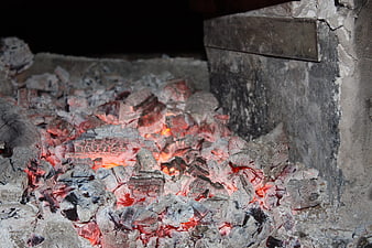 Glowing charcoal embers in a rustic brick kiln