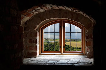 Arched stone window with rural landscape view