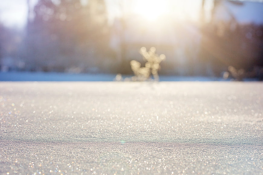 Sparkling Snow Texture with Sunlight and Bokeh Background
