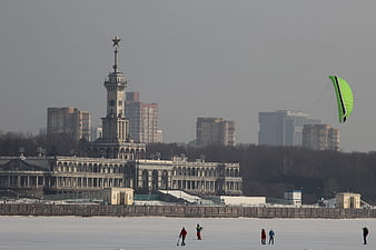 Winter cityscape with kite skier on frozen river
