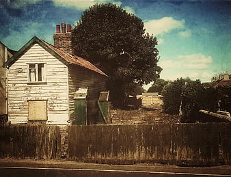 Vintage Weathered Cottage with Peeling Paint and Wooden Fence