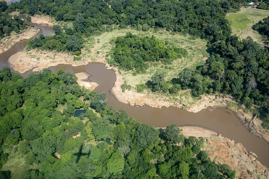 Aerial view of winding river through lush green forest landscape