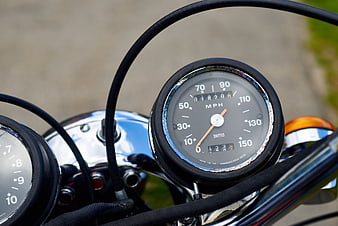Close-up of vintage motorcycle speedometer and chrome handlebars
