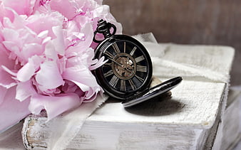 Vintage pocket watch and pink peony on old books