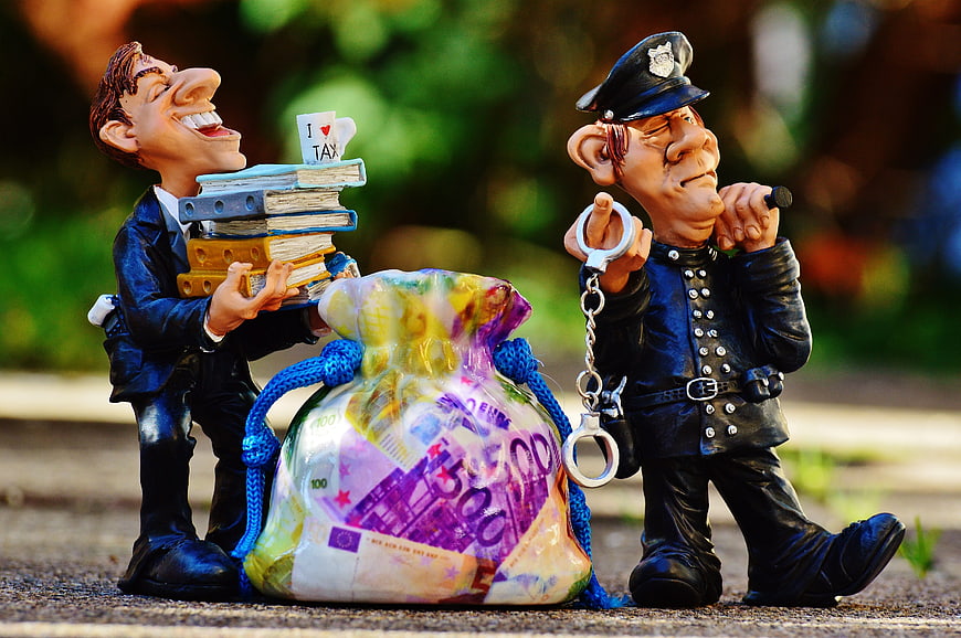 Tax Evasion Concept with Figurines and Money Bag