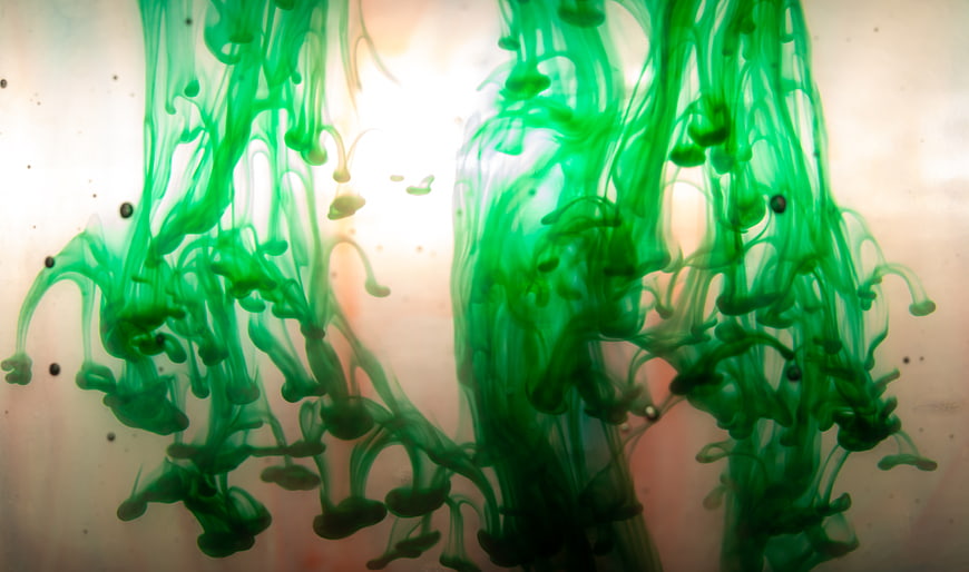 Abstract Green Ink Drops Swirling in Water