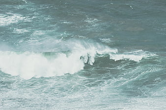 Aerial view of crashing ocean waves with white foam