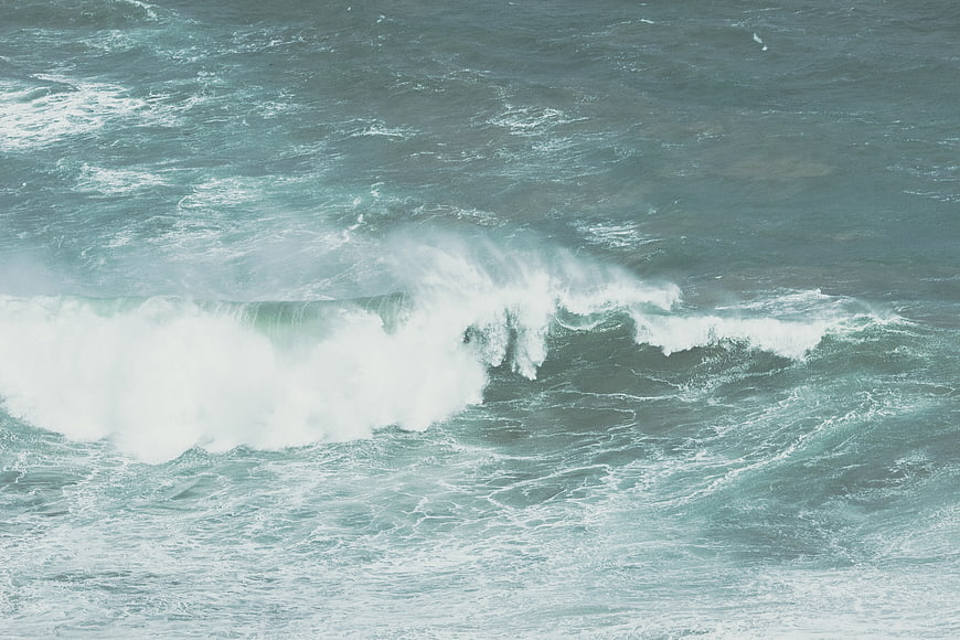 Aerial view of crashing ocean waves with white foam