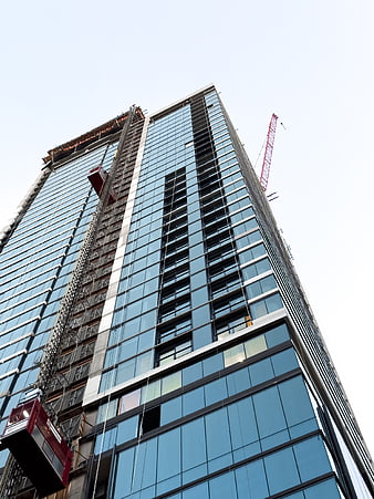 Low angle view of modern glass skyscraper under construction