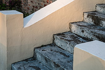 Weathered Concrete Staircase With Cream Handrail And Warm Sunlight