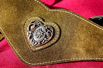 Close-up of brown suede belt with silver heart buckle