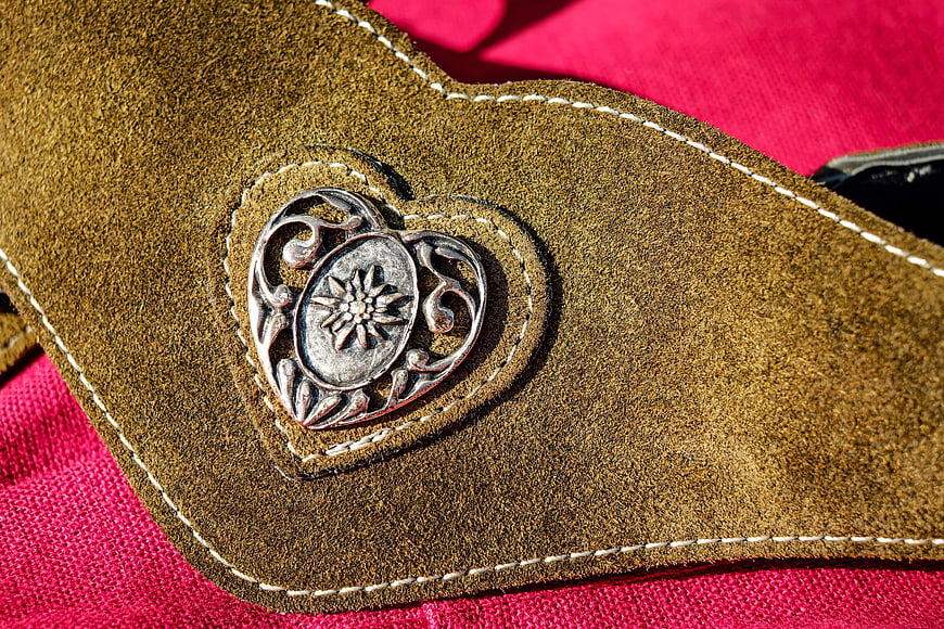 Close-up of brown suede belt with silver heart buckle