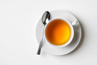 Overhead View of Amber Tea in White Cup with Spoon